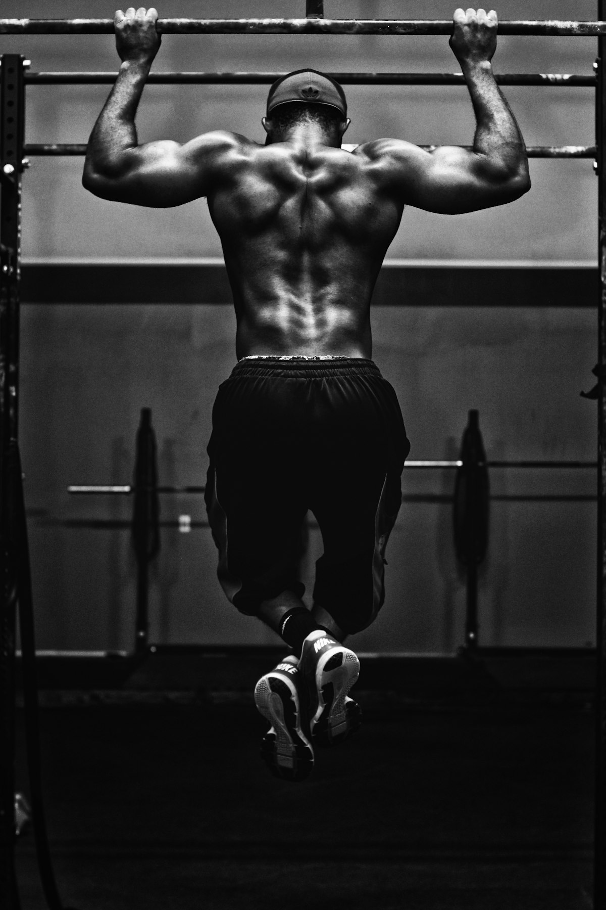 Atleta haciendo dominadas en una barra, foto en blanco y negro de alto contraste